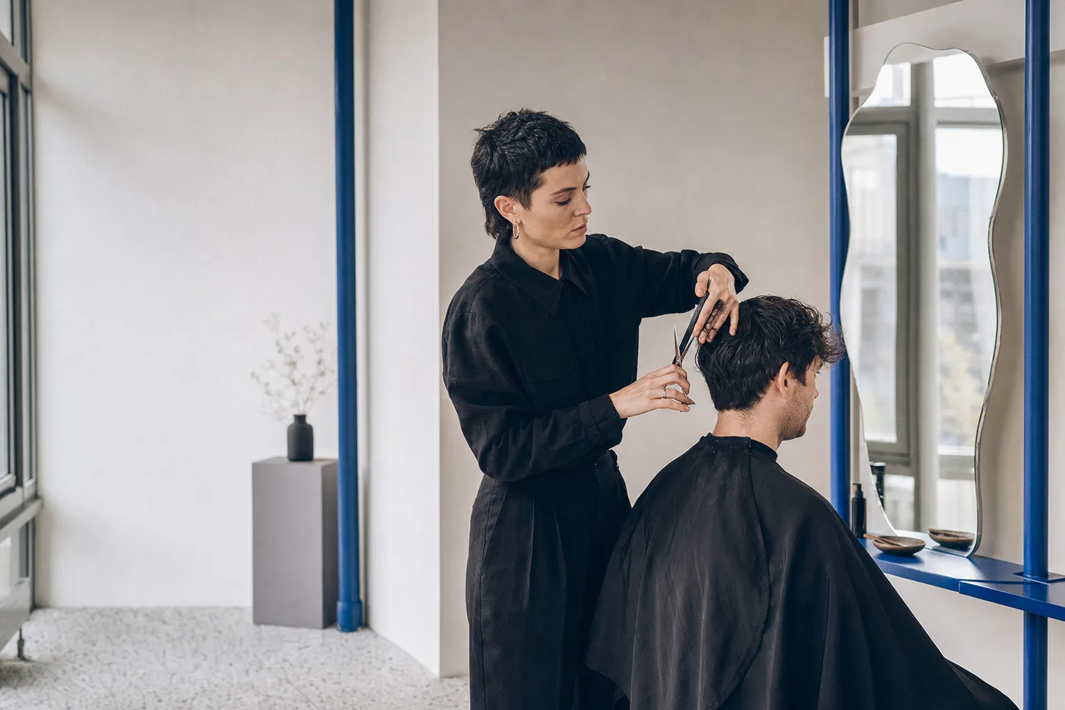 Kapper knipt kort haar in een lichte, moderne salon